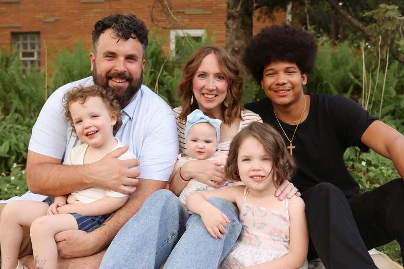 A family smiling together outdoors