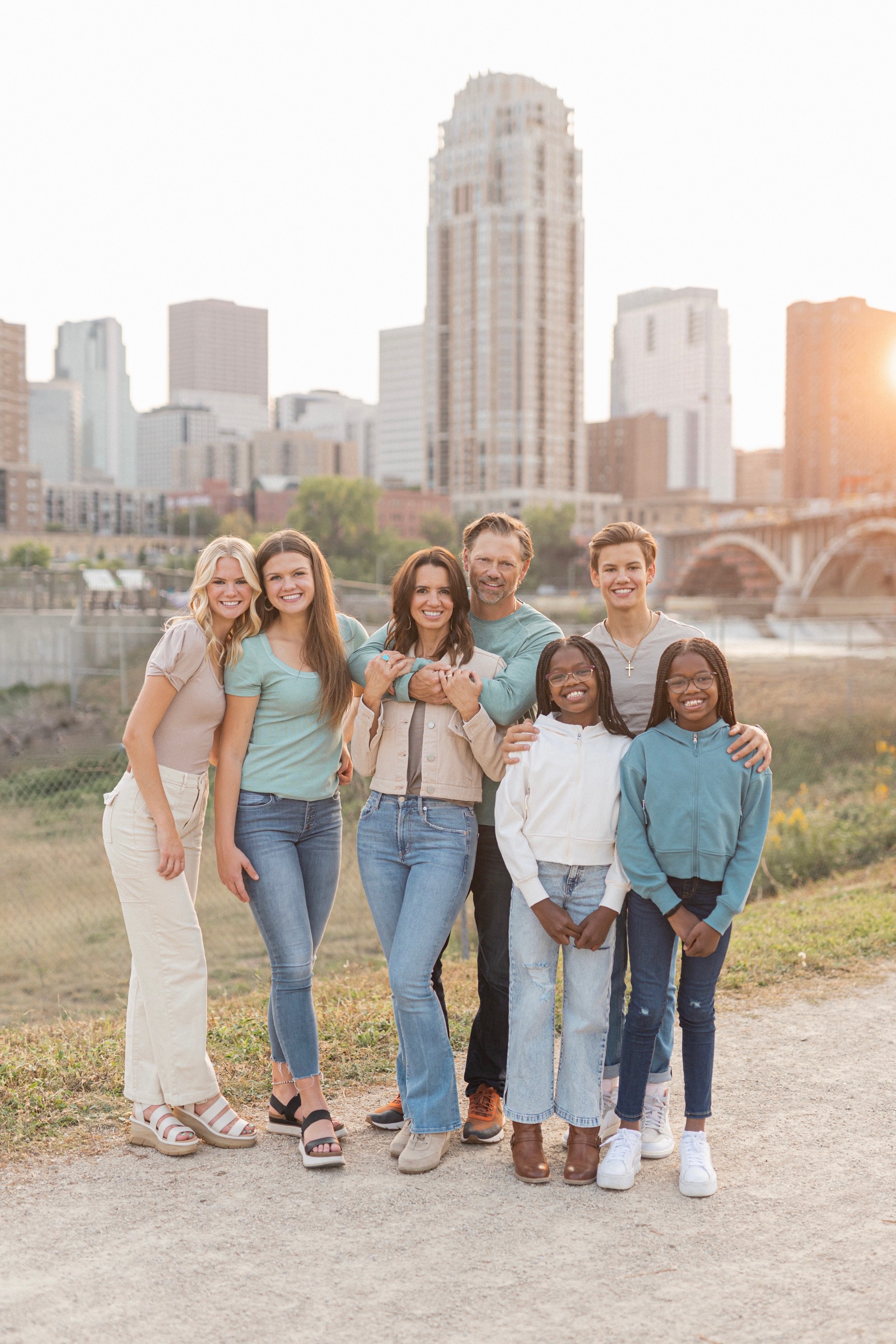A smiling family standing together near a city skyline