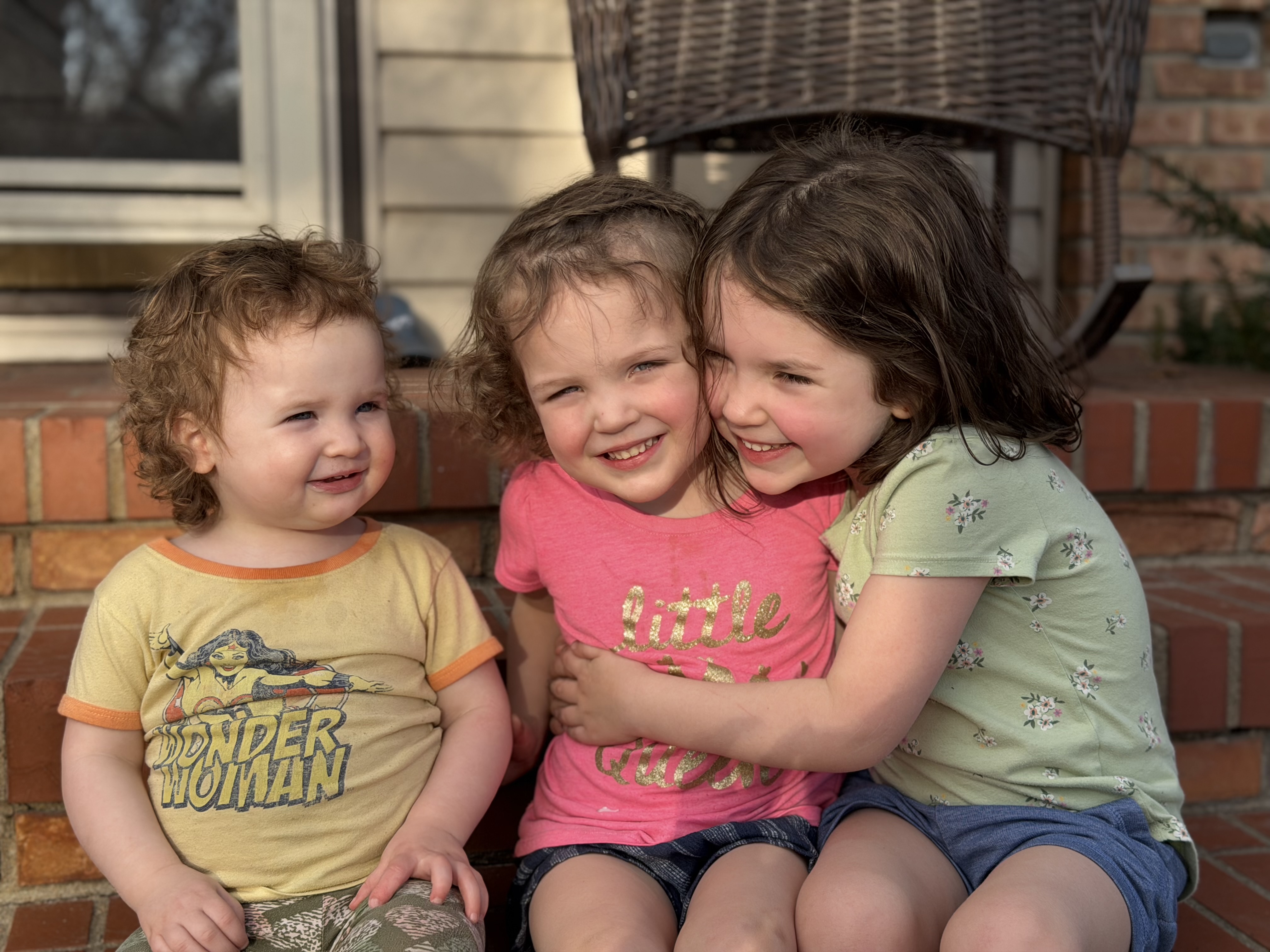 Three siblings sitting together and smiling